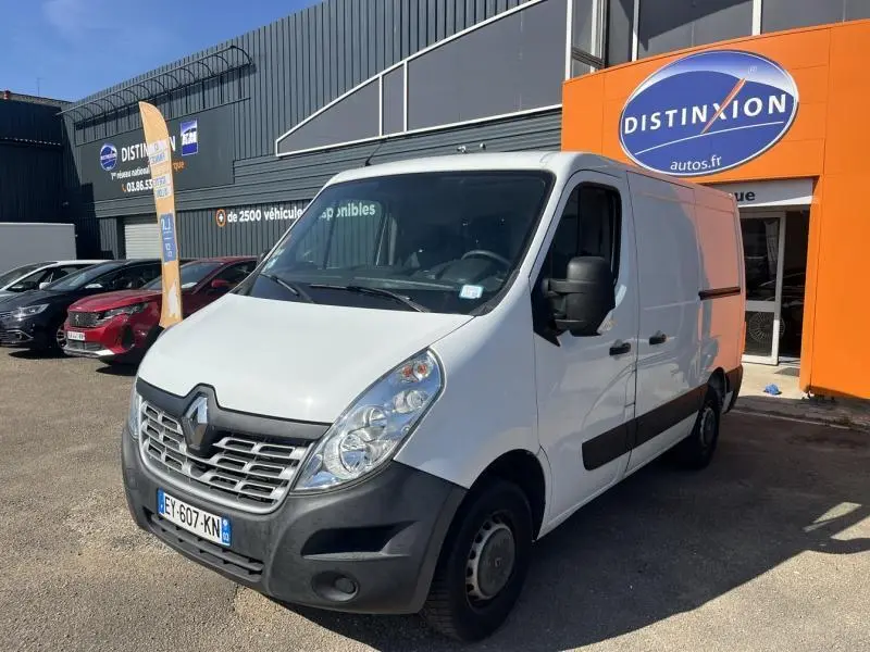 Renault Master blanc glacier vu en 3/4 avant droit, avec calandre et pare-chocs noirs devant un garage Distinxion.
