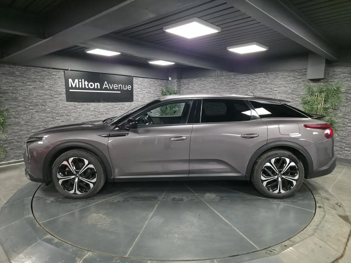 Profil côté gauche d'une Citroën C5 X hybride rechargeable gris métallisé avec jantes alliage 19 pouces AeroX.