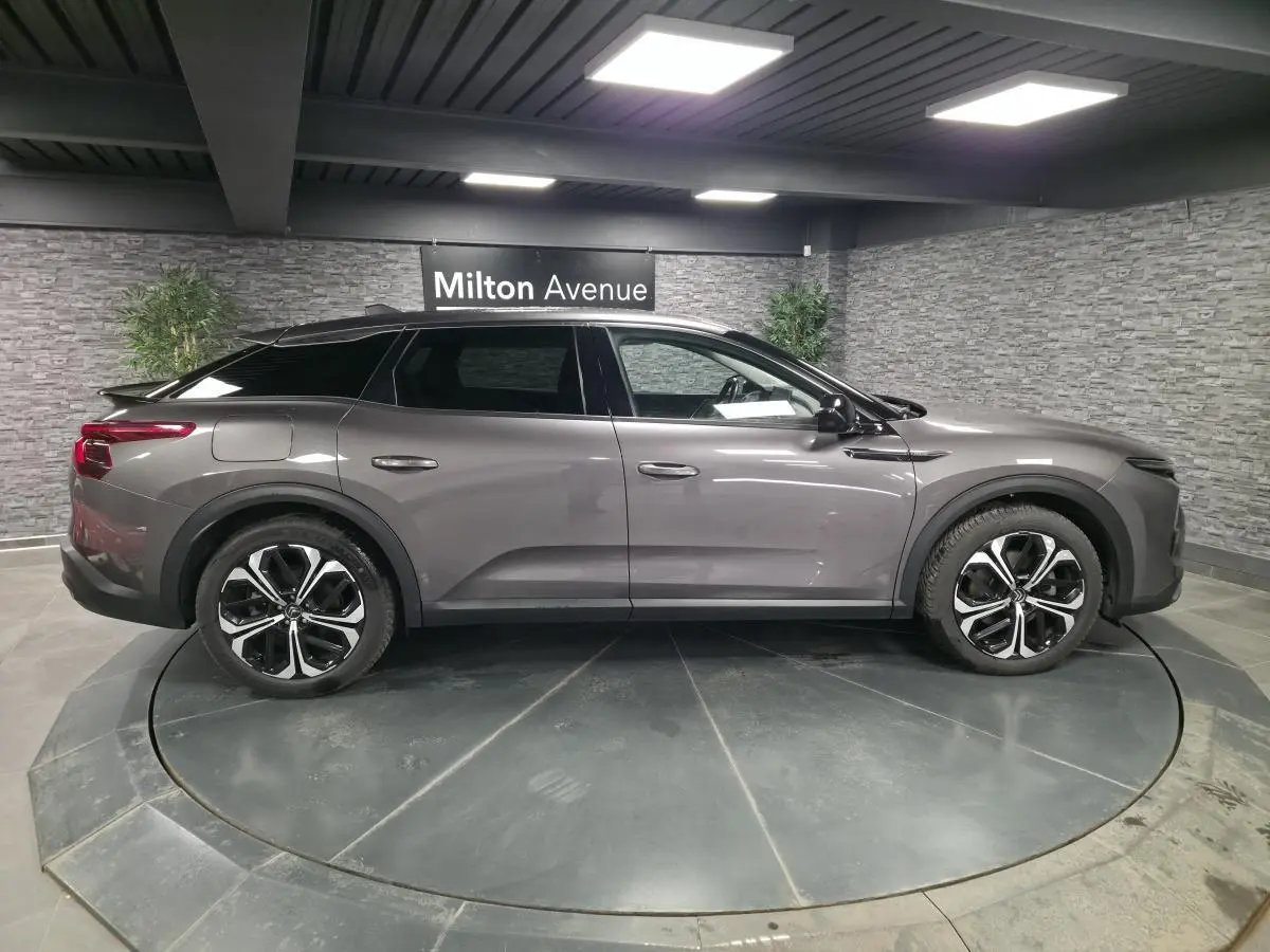 Vue latérale droite d'une Citroën C5 X gris métallisé avec toit noir et jantes alliage 19 pouces AeroX.