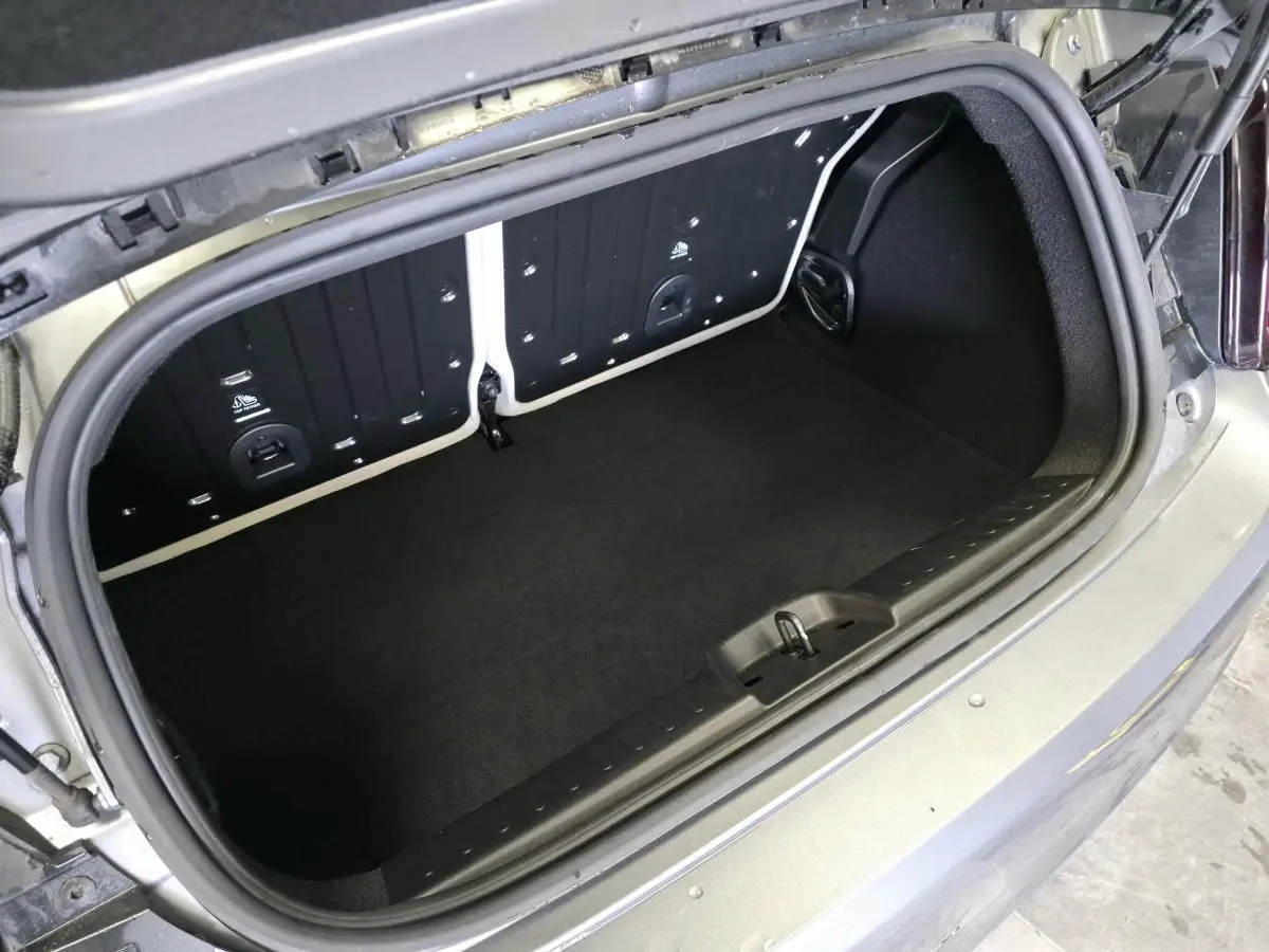 Coffre ouvert vu de dessus de la Fiat 500 Cabriolet électrique gris foncé avec banquette arrière rabattue.