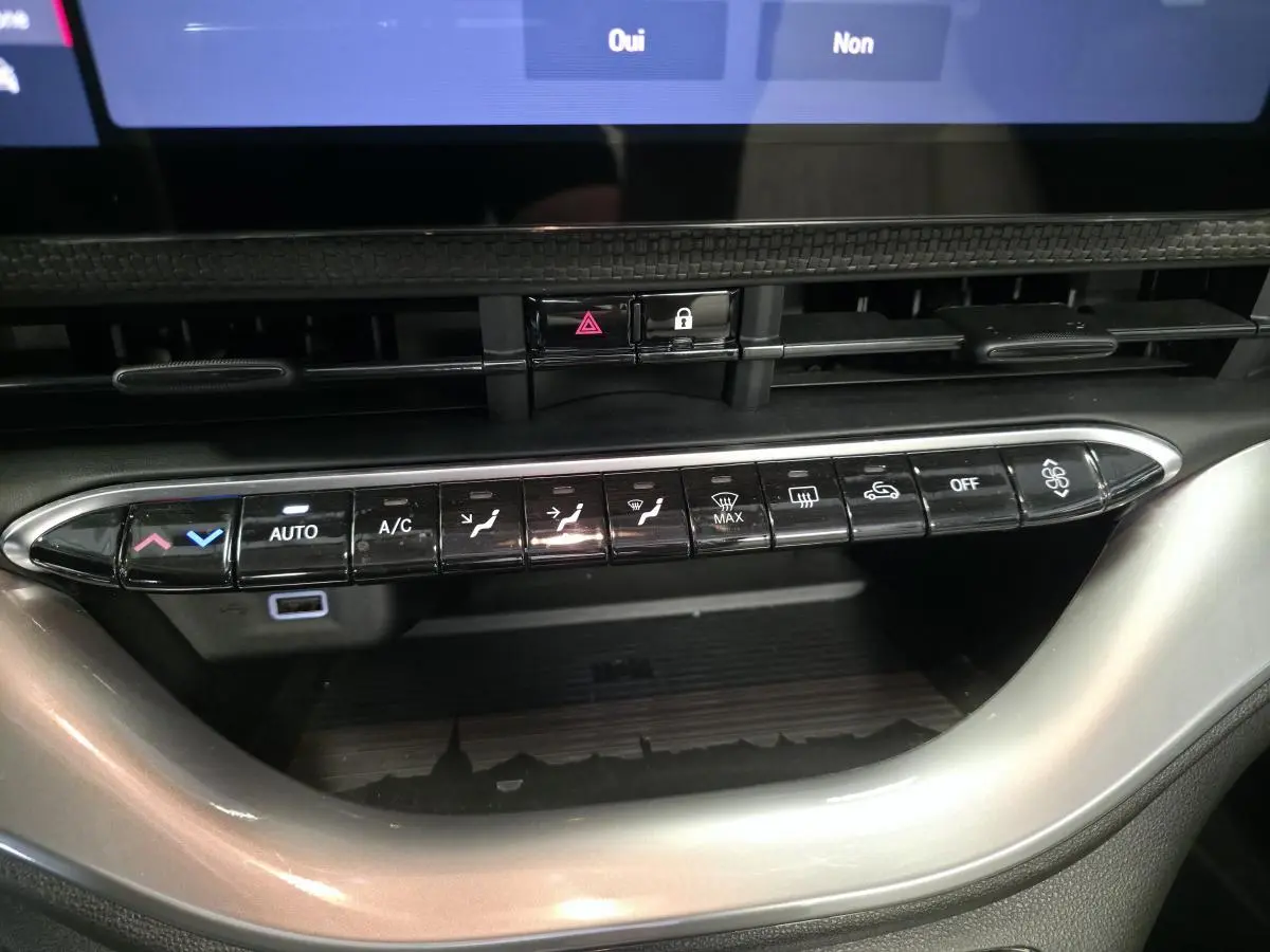 Gros plan sur la console centrale de la Fiat 500 Cabriolet électrique 2022, boutons de climatisation et ventilation visibles.