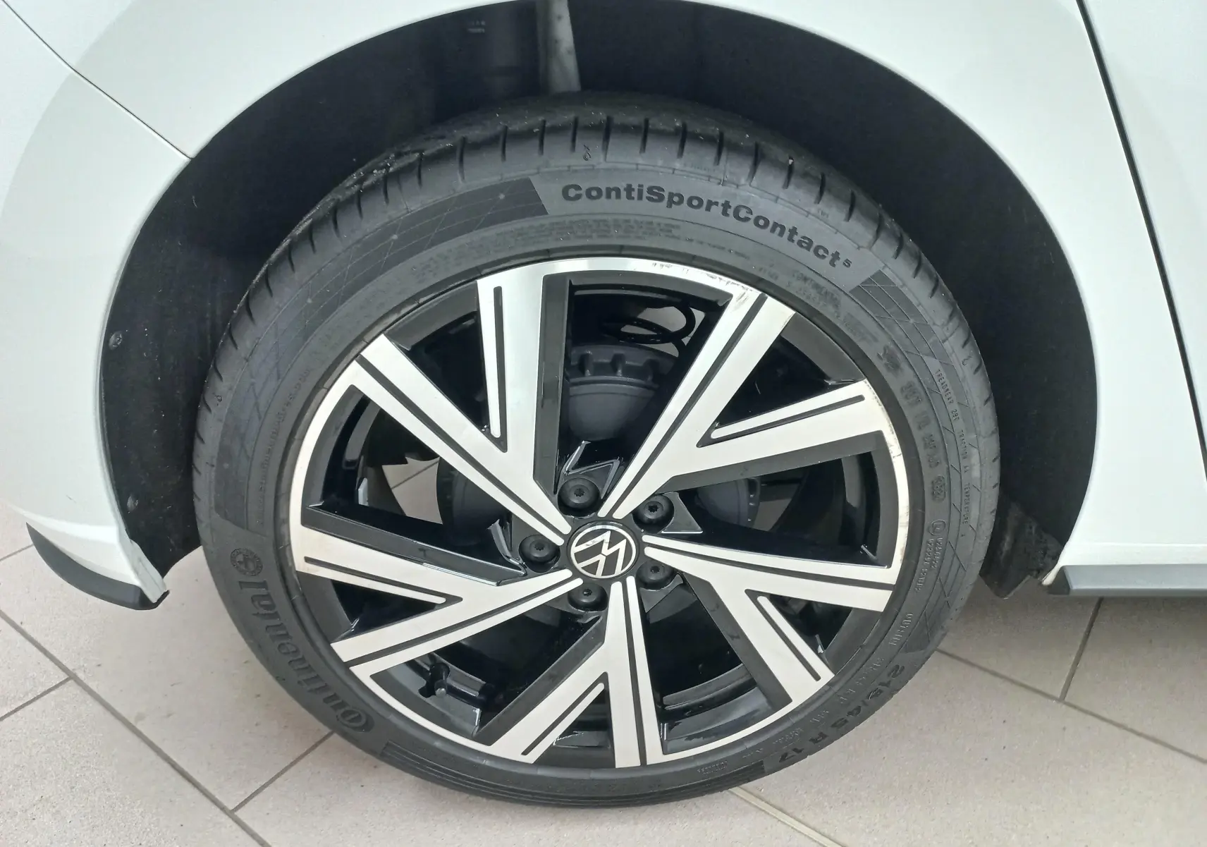 Gros plan sur la roue avant droite d'une Volkswagen Polo blanc pur avec jante alliage R-Line bicolore.