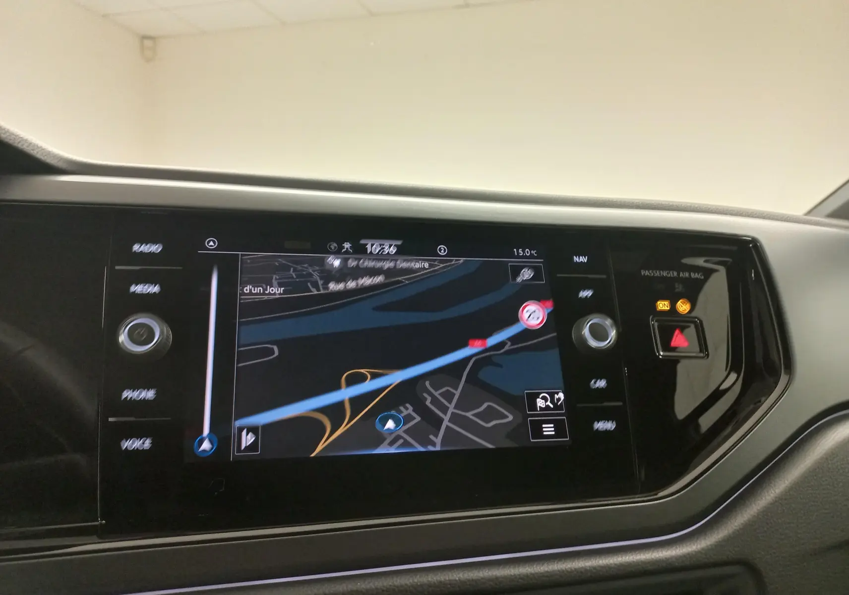 Écran de navigation tactile du Volkswagen Polo 2025 montrant une carte avec itinéraire, boutons et voyants du tableau de bord.