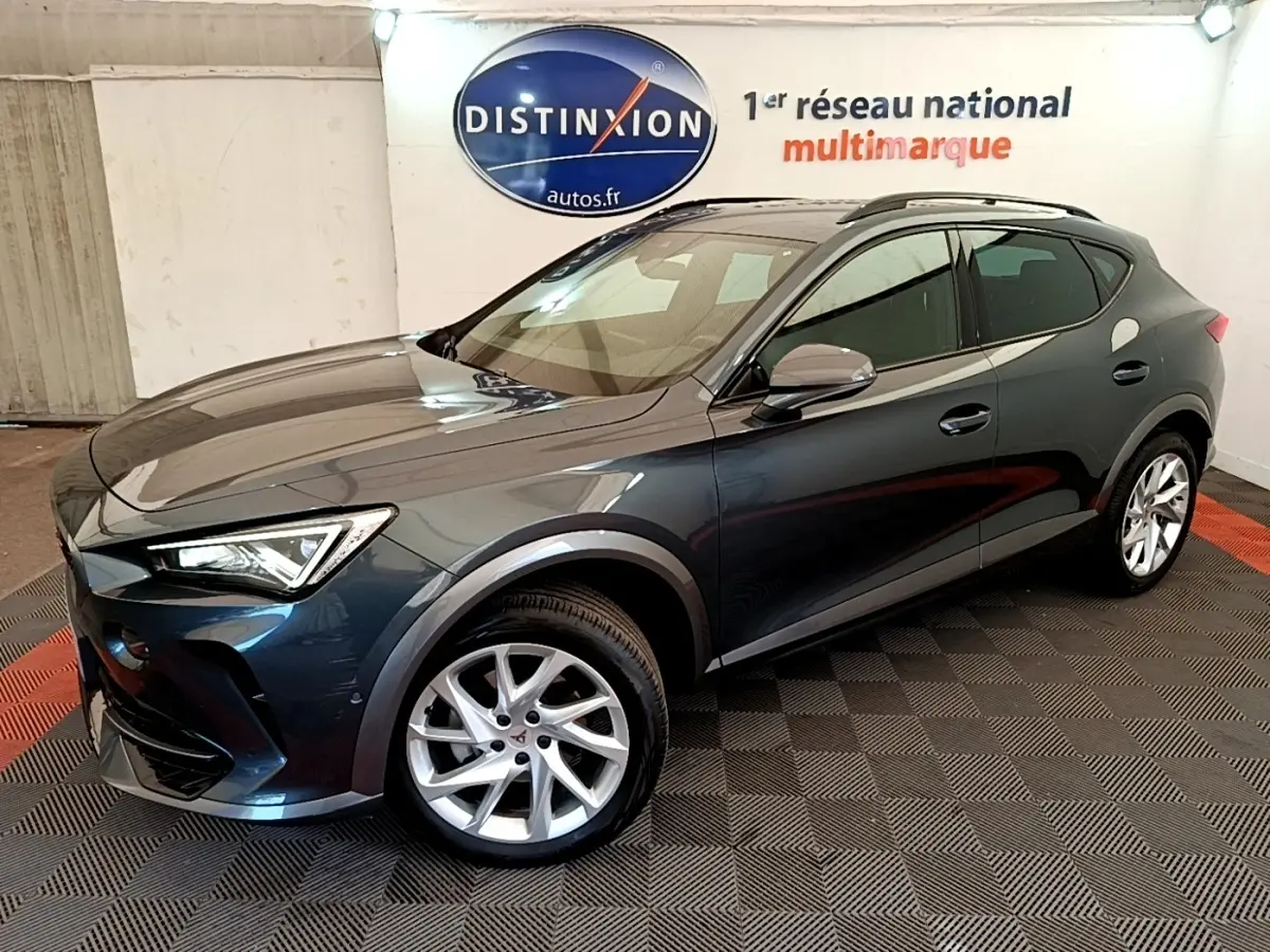 Vue 3/4 avant d'un CUPRA Formentor gris foncé avec jantes argentées dans un showroom intérieur.