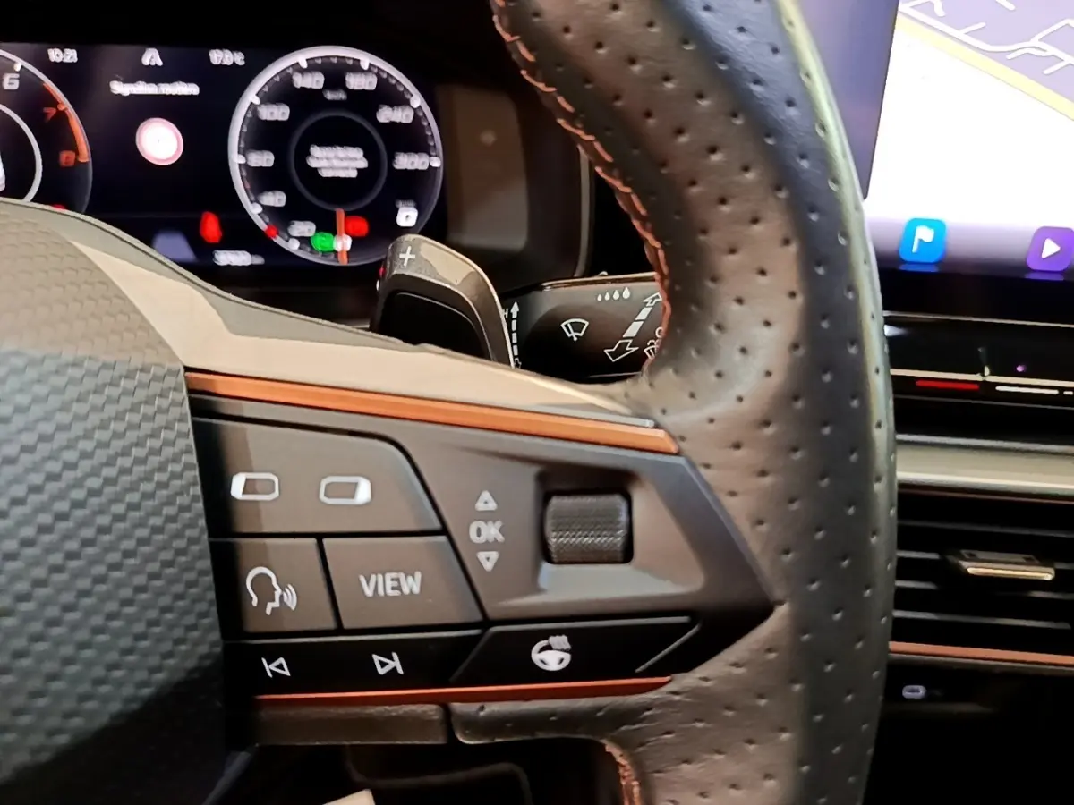 Gros plan sur le volant cuir perforé de la CUPRA Formentor 2022, avec commandes multifonctions et tableau de bord numérique.