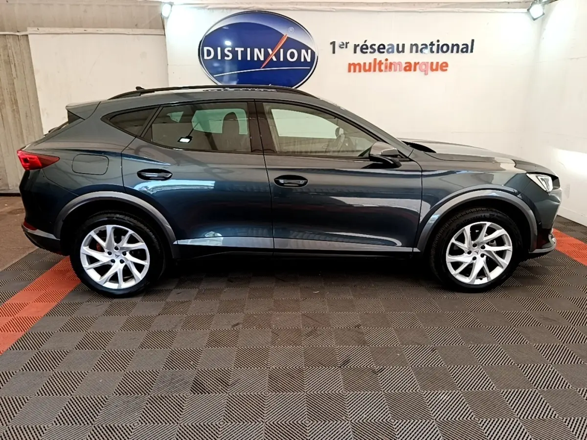 Vue de profil côté gauche d’un CUPRA Formentor gris foncé, SUV compact avec jantes alliage et lignes dynamiques.