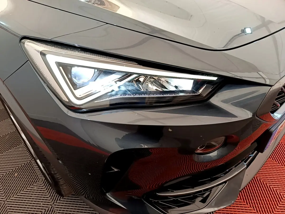 Gros plan sur le phare avant gauche du CUPRA Formentor gris foncé, mettant en valeur son design LED anguleux.