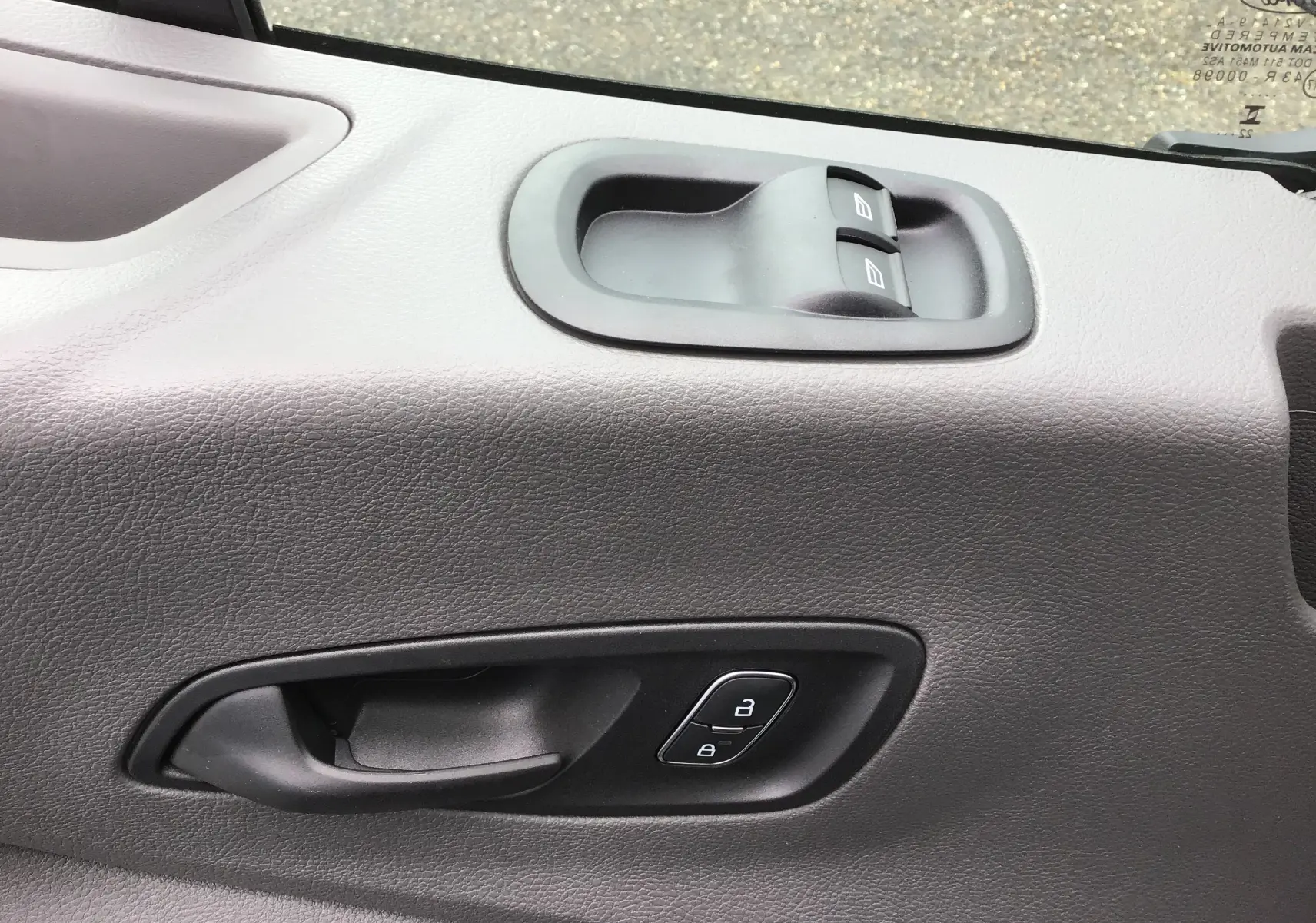 Détail de la porte côté conducteur du Ford Transit Fourgon blanc 2023, montrant les commandes de vitres et de verrouillage.