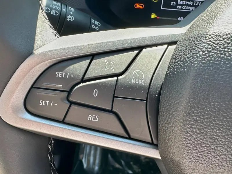 Gros plan sur les commandes de régulateur de vitesse au volant du Dacia Bigster 2025, intérieur noir.