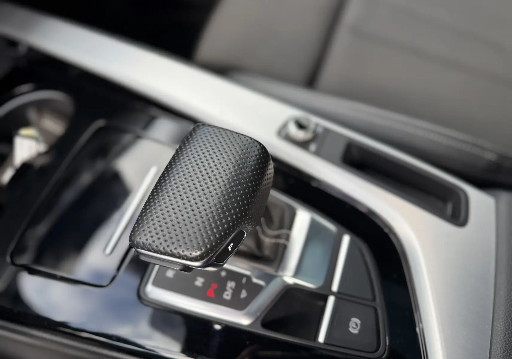 Le levier de vitesse en cuir perforé de l'Audi A4 Avant gris Daytona, vue rapprochée de la console centrale.