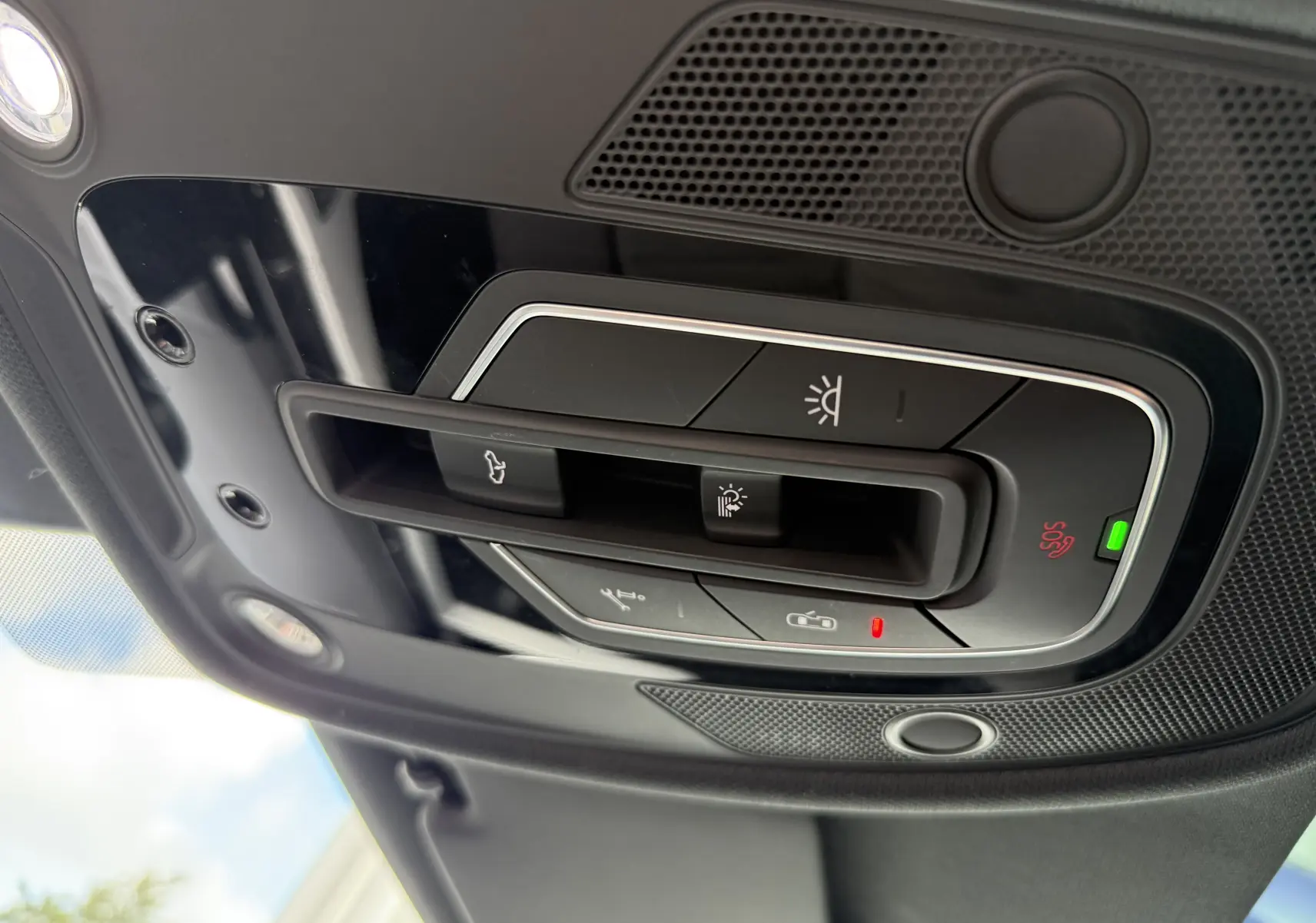 Vue en gros plan du plafonnier noir brillant avec commandes d’éclairage et bouton SOS de l’Audi A4 Avant gris Daytona 2023.