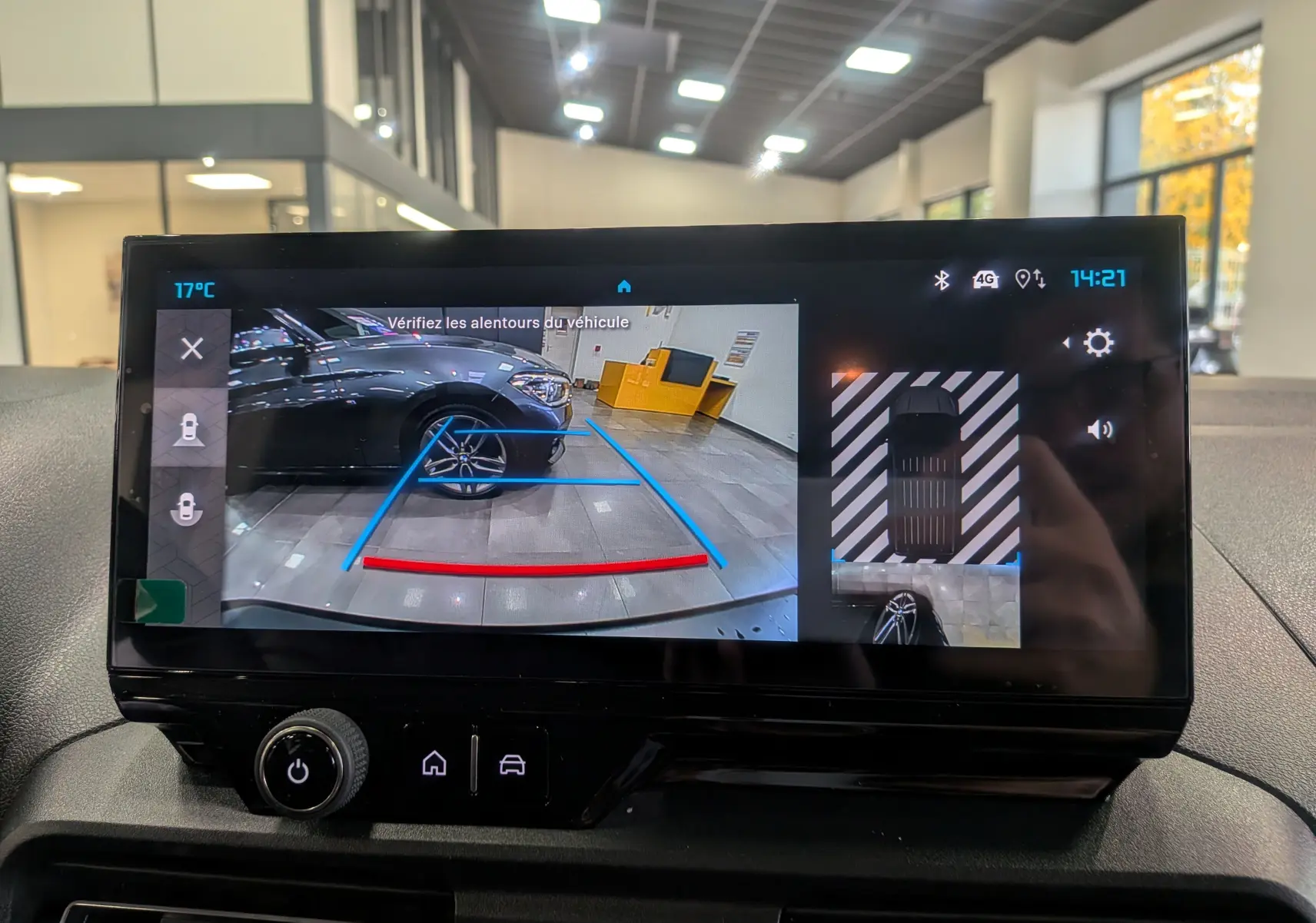 Écran de caméra de recul du Citroën Berlingo blanc glacier, montrant l'arrière et le côté droit en intérieur showroom.