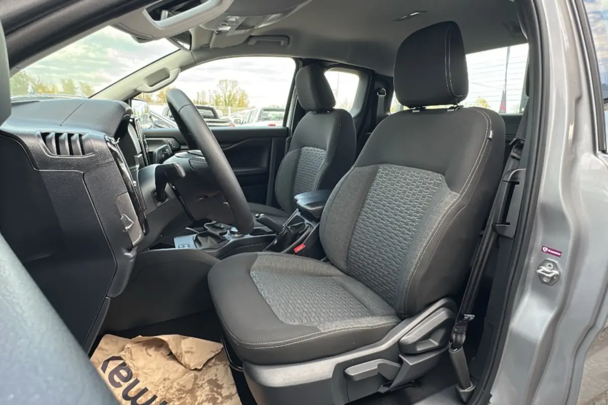 Vue intérieure côté conducteur du Ford Ranger gris iconic 2026, montrant sièges tissu bicolore et volant multifonctions cuir.