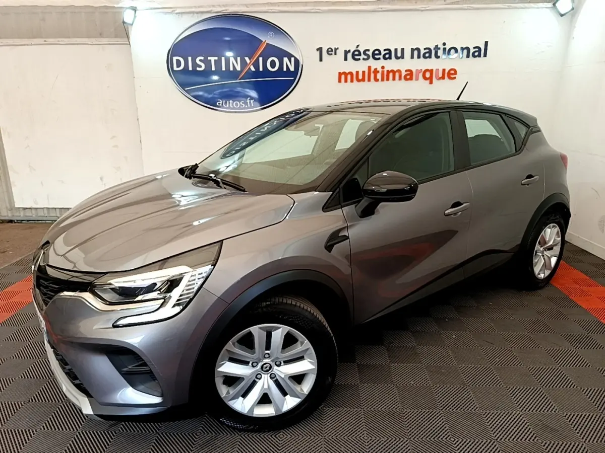 Renault Captur Zen E-Tech hybride gris foncé vu en 3/4 avant droit dans un showroom intérieur.