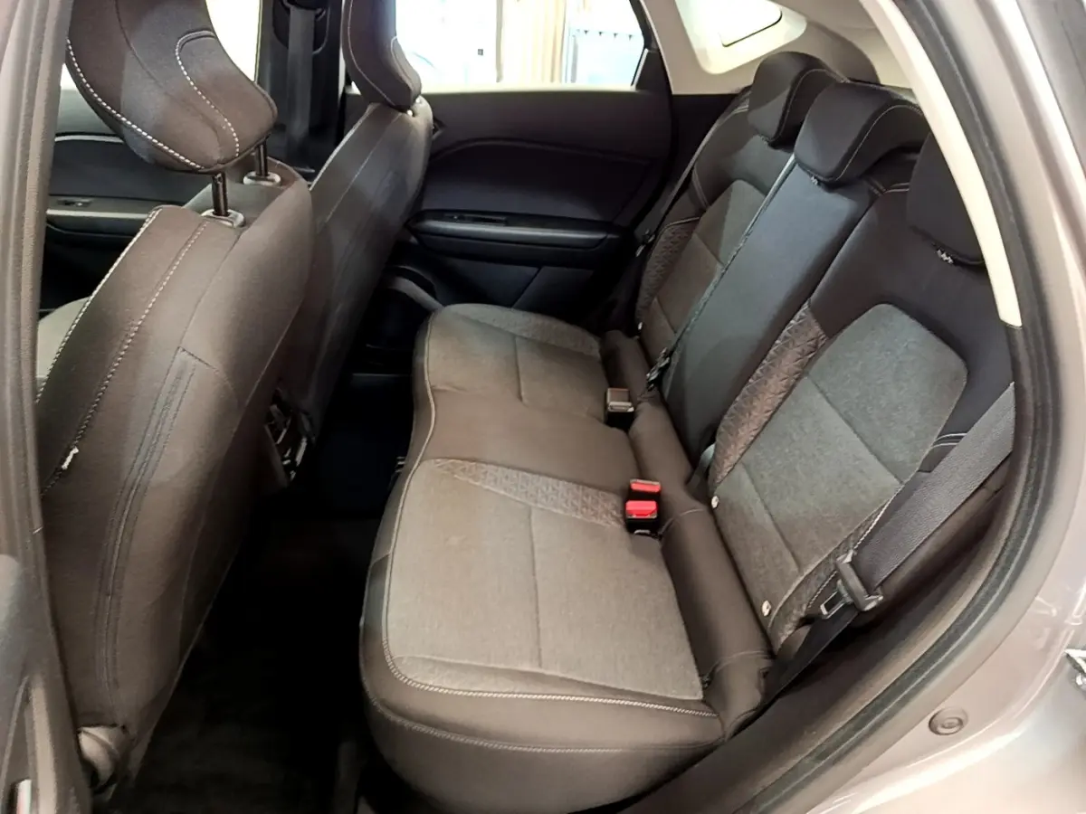 Vue intérieure côté droit montrant la banquette arrière grise du Renault Captur Zen E-Tech hybride 2022 avec ceintures de sécurité.