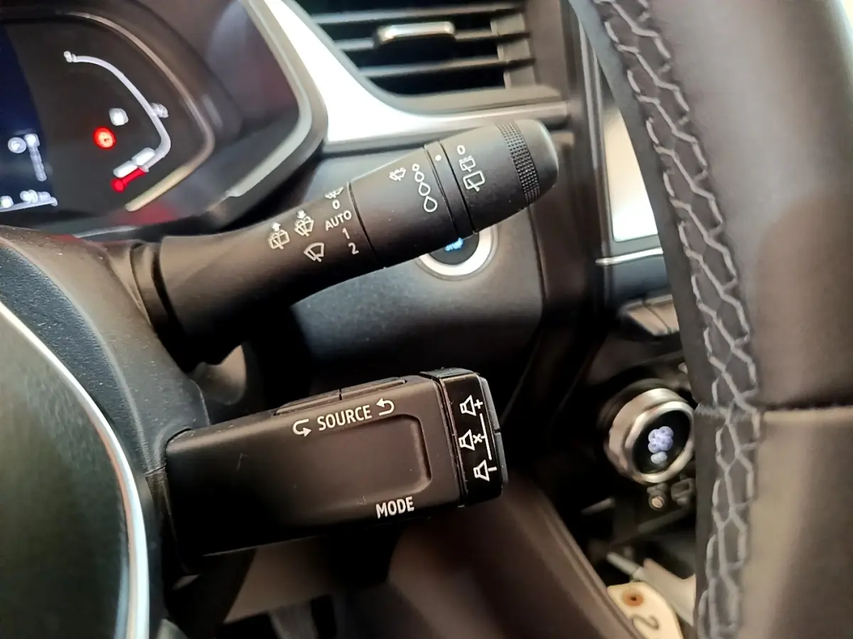 Gros plan sur la commande multifonction et le commodo d’essuie-glace du tableau de bord d’un Renault Captur gris foncé 2022.