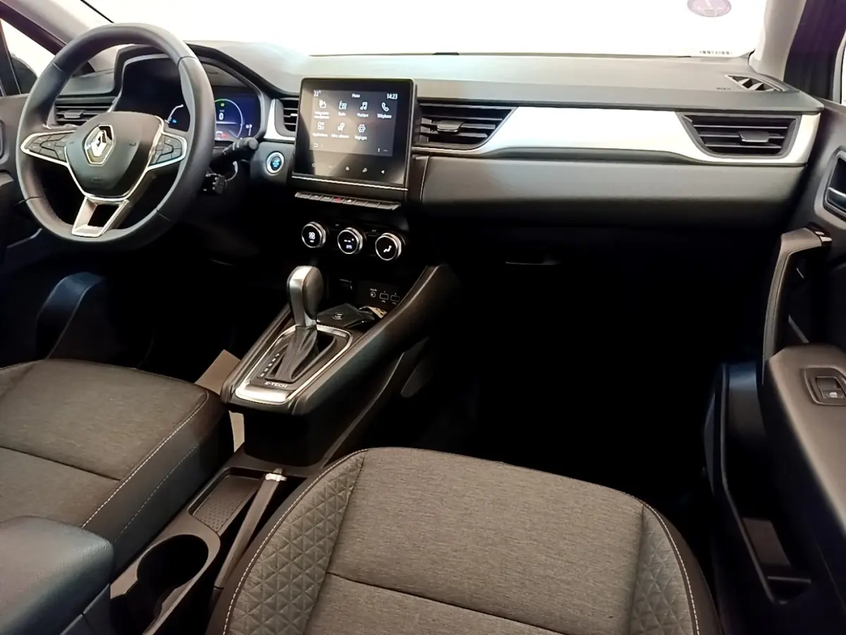 Intérieur du Renault Captur Zen E-Tech 2022 vu de l'avant, tableau de bord moderne avec écran tactile central et volant multifonctions.