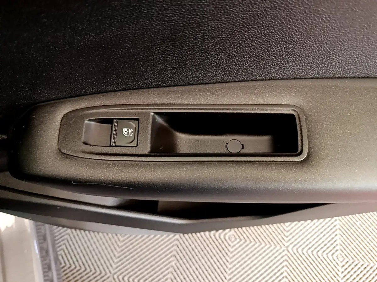 Gros plan sur la commande de lève-vitre côté conducteur du Renault Captur Zen E-Tech hybride gris foncé 2022.