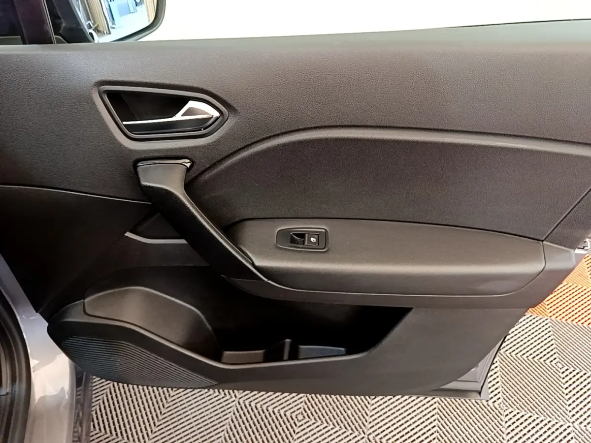 Vue rapprochée de la porte intérieure côté droit du Renault Captur gris foncé, montrant la poignée et le bouton de verrouillage.