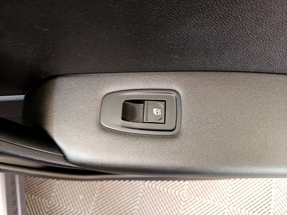 Gros plan sur le bouton de commande de la lunette arrière chauffante, intérieur noir du Renault Captur Zen E-Tech gris foncé.