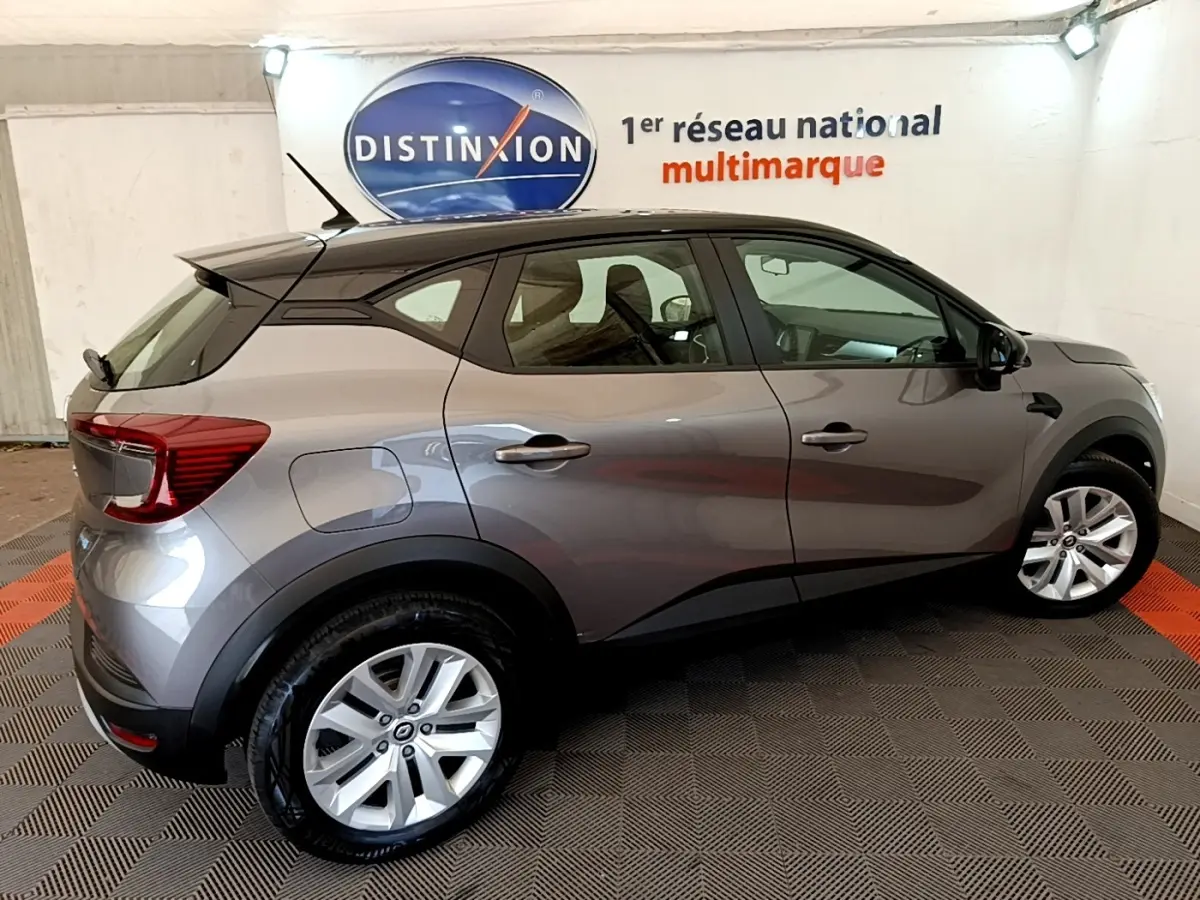 Renault Captur Zen E-Tech hybride gris foncé vu de profil côté droit dans un showroom intérieur.