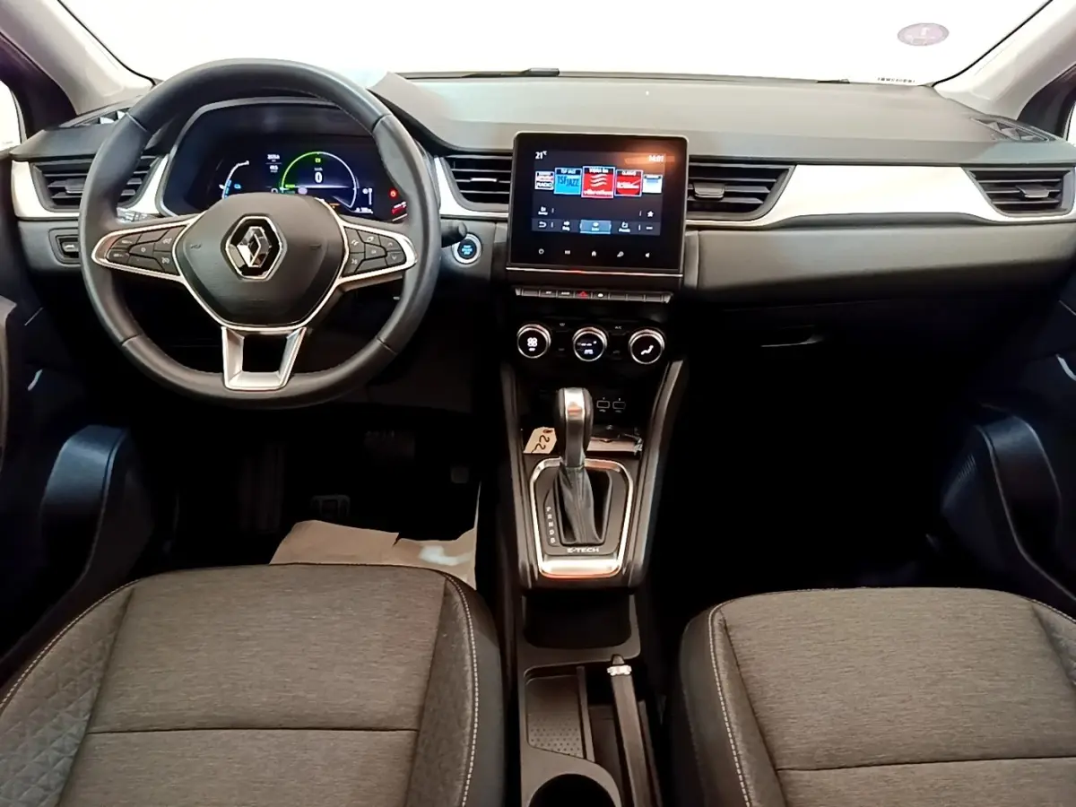 Vue intérieure avant du Renault Captur Zen E-Tech hybride 2022, tableau de bord noir avec écran tactile central et volant multifonctions.