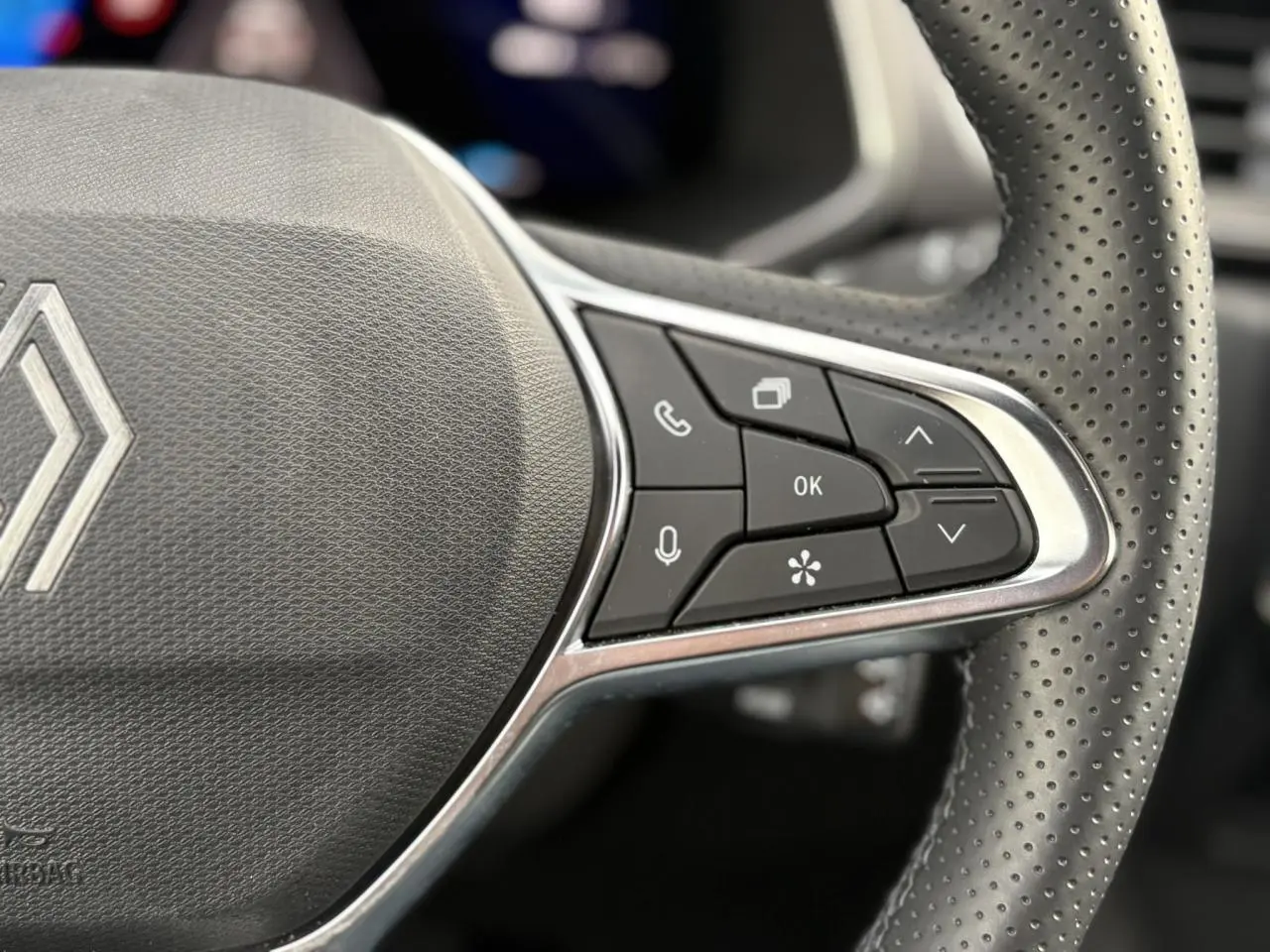 Gros plan sur les commandes à droite du volant en cuir perforé de la Renault Symbioz bleu Iron.