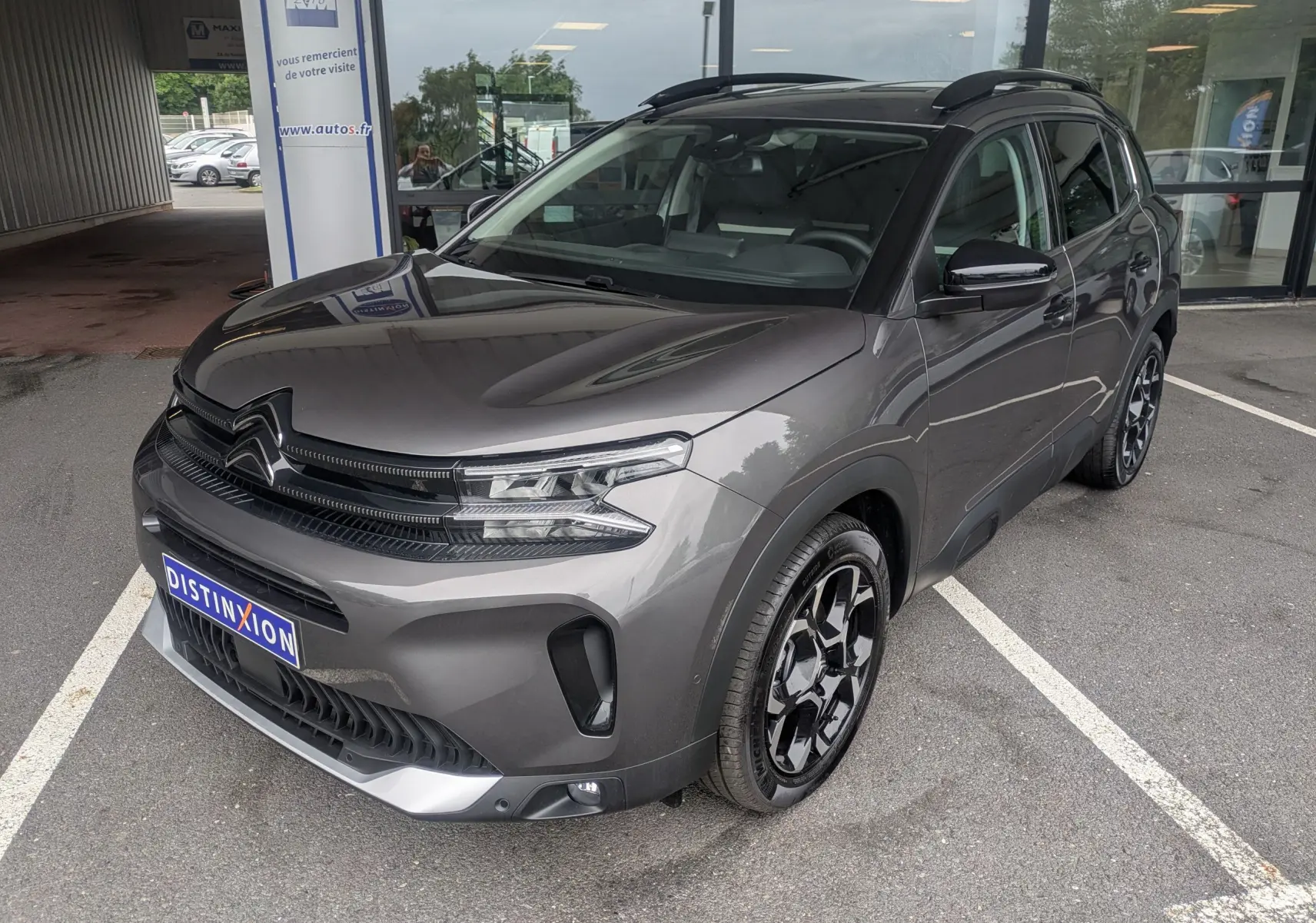 Vue 3/4 avant droite du Citroën C5 Aircross hybride gris platinium avec jantes biton 18 pouces et toit panoramique.