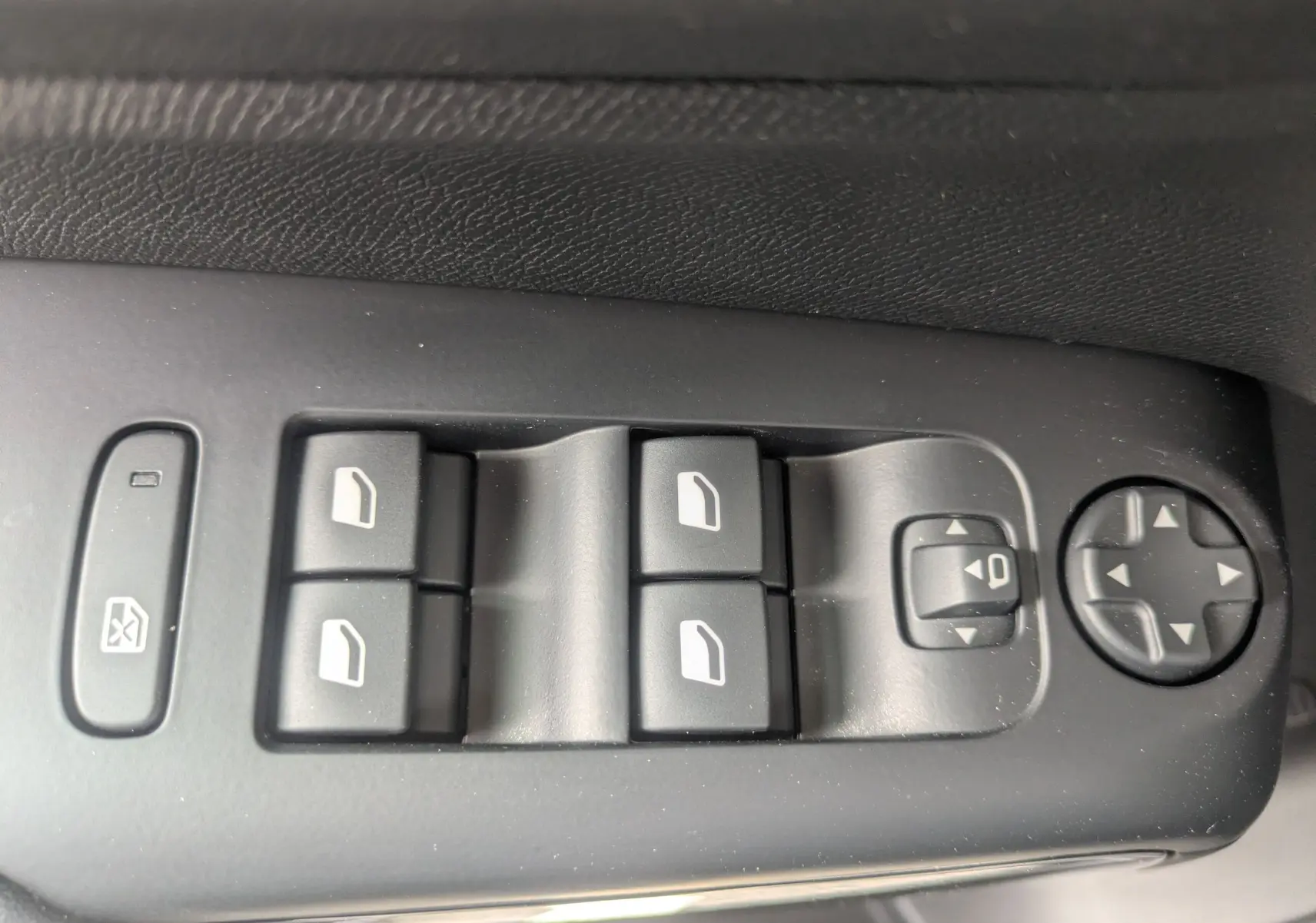 Gros plan sur les commandes de lève-vitres et réglage des rétroviseurs côté conducteur du Citroën C5 Aircross gris platinium.