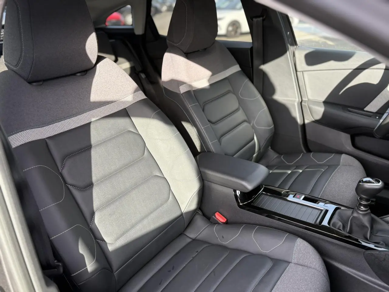 Vue intérieure des sièges avant gris et noir de la Citroën C4 PureTech 130 avec console centrale et levier de vitesses manuel.