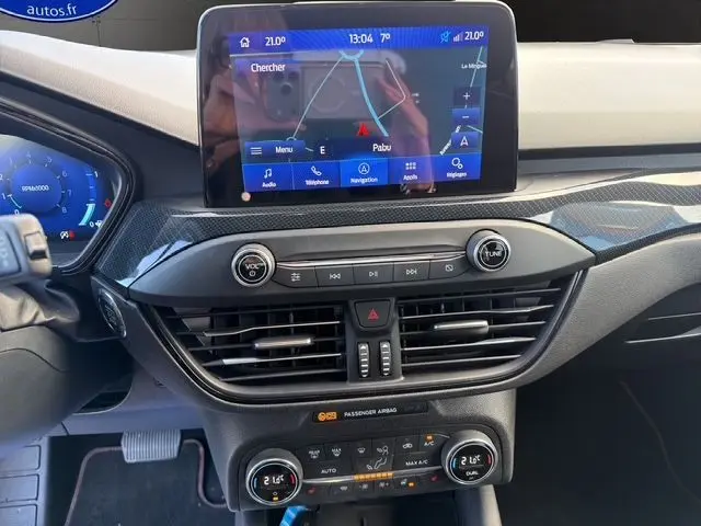 Vue intérieure du tableau de bord de la Ford Focus 1.5 EcoBoost 150ch ST-Line 2022 avec écran tactile et commandes climatisation.