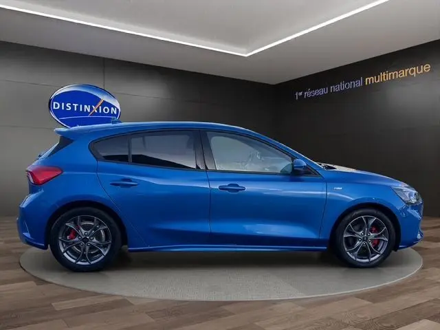 Vue latérale droite d'une Ford Focus 1.5 EcoBoost ST-Line 2022 bleu vif avec jantes alliage et étriers de frein rouges.