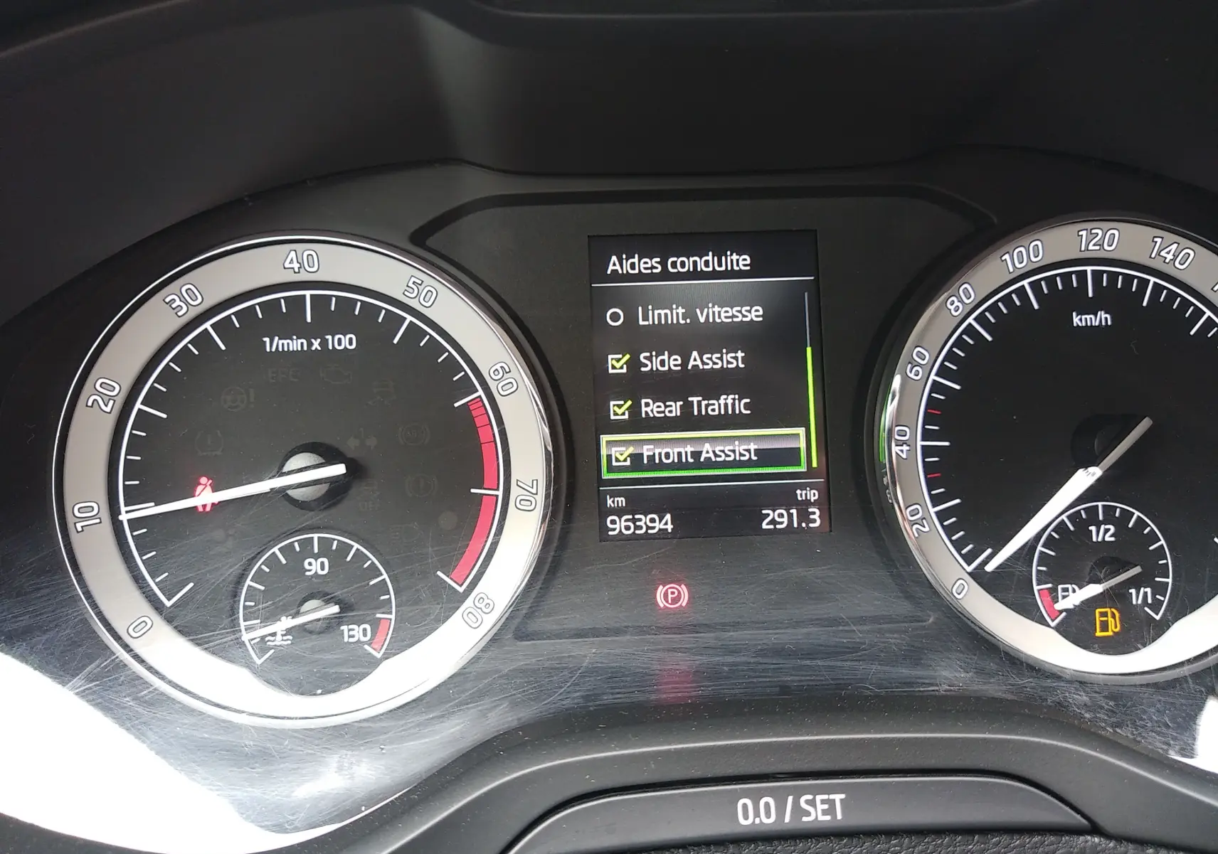 Tableau de bord du Skoda Karoq gris 2021, affichant les aides à la conduite et compteurs vitesse et régime moteur.
