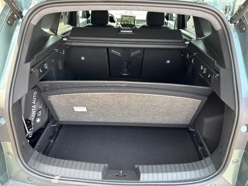 Vue arrière du coffre ouvert du Dacia Bigster blanc, montrant le cache-bagages et l'intérieur spacieux noir.