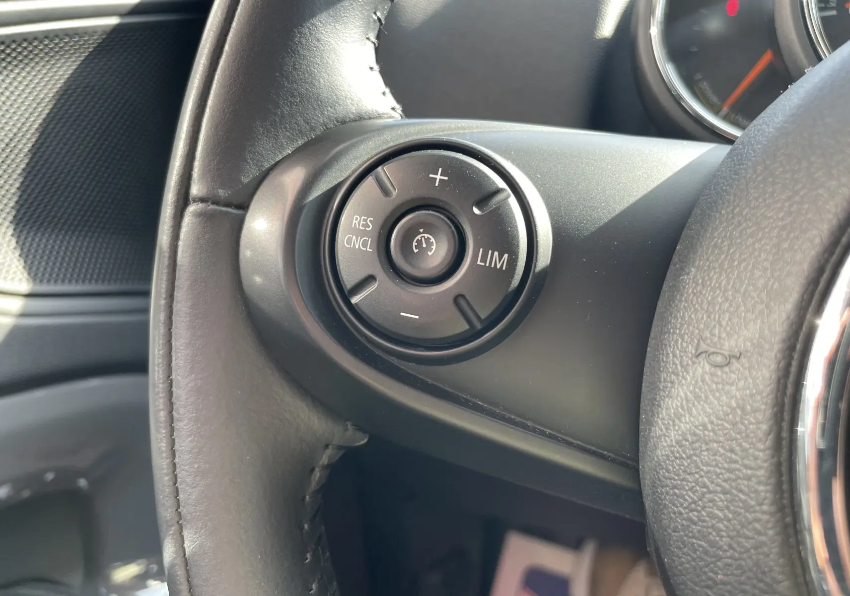 Gros plan sur les commandes de régulateur de vitesse au volant cuir noir d'une MINI Countryman F60 Moonwalk Grey 2019.