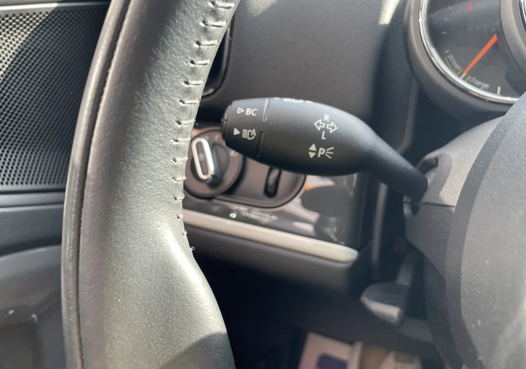 Gros plan sur la manette de clignotants à gauche du volant dans l'habitacle gris-noir d'une MINI Countryman Moonwalk Grey.