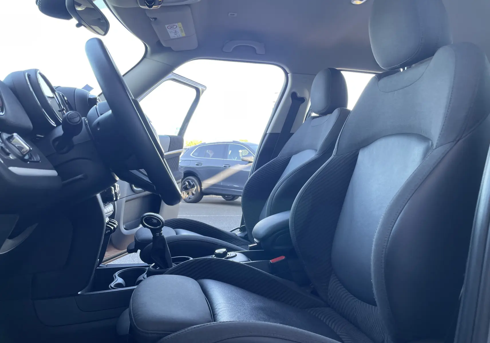 Vue intérieure côté conducteur du MINI Countryman F60 gris Moonwalk, mettant en valeur les sièges avant et le volant.