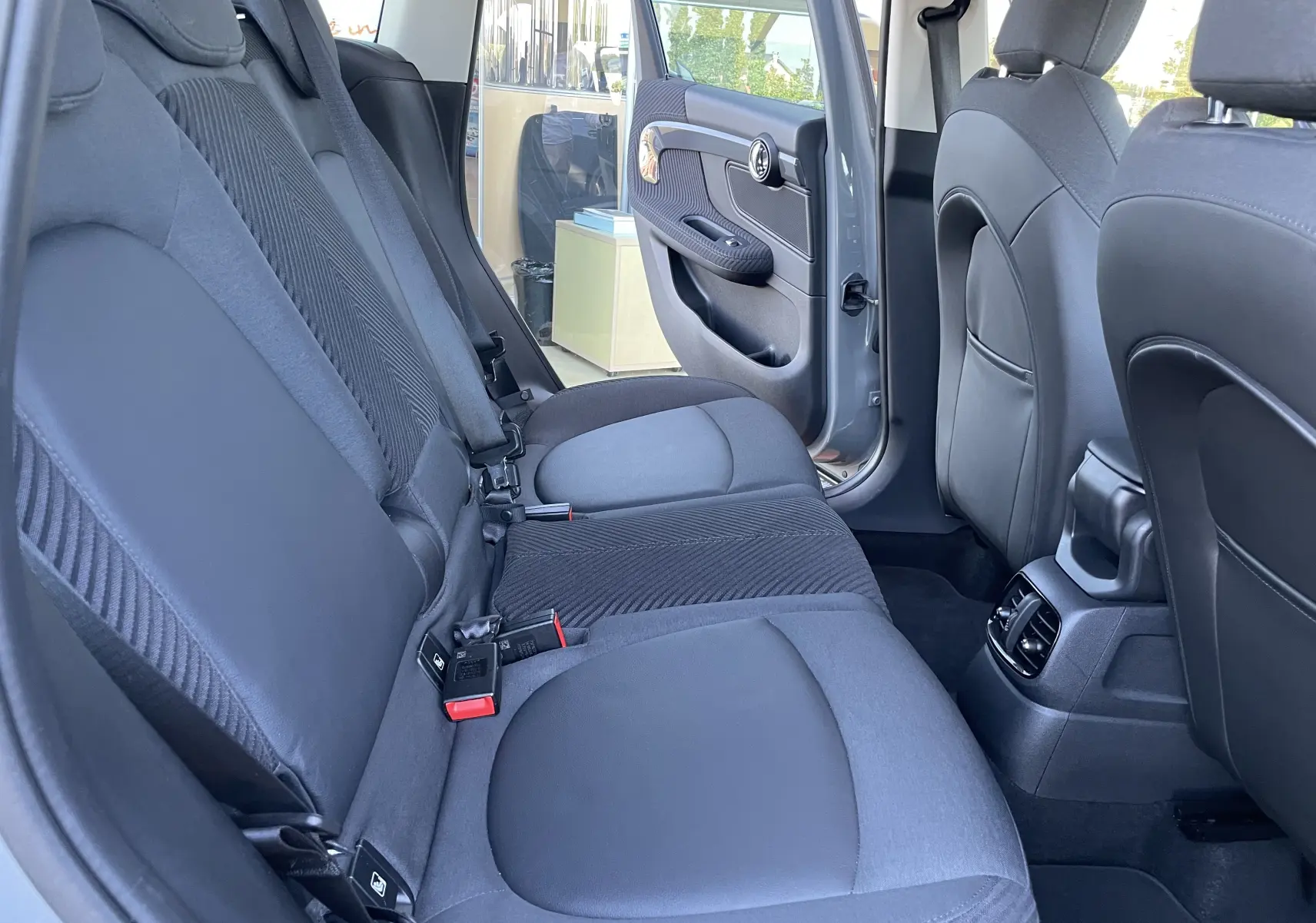 Vue intérieure arrière côté droit du MINI COUNTRYMAN F60 hybride rechargeable gris Moonwalk, sièges tissu gris foncé.