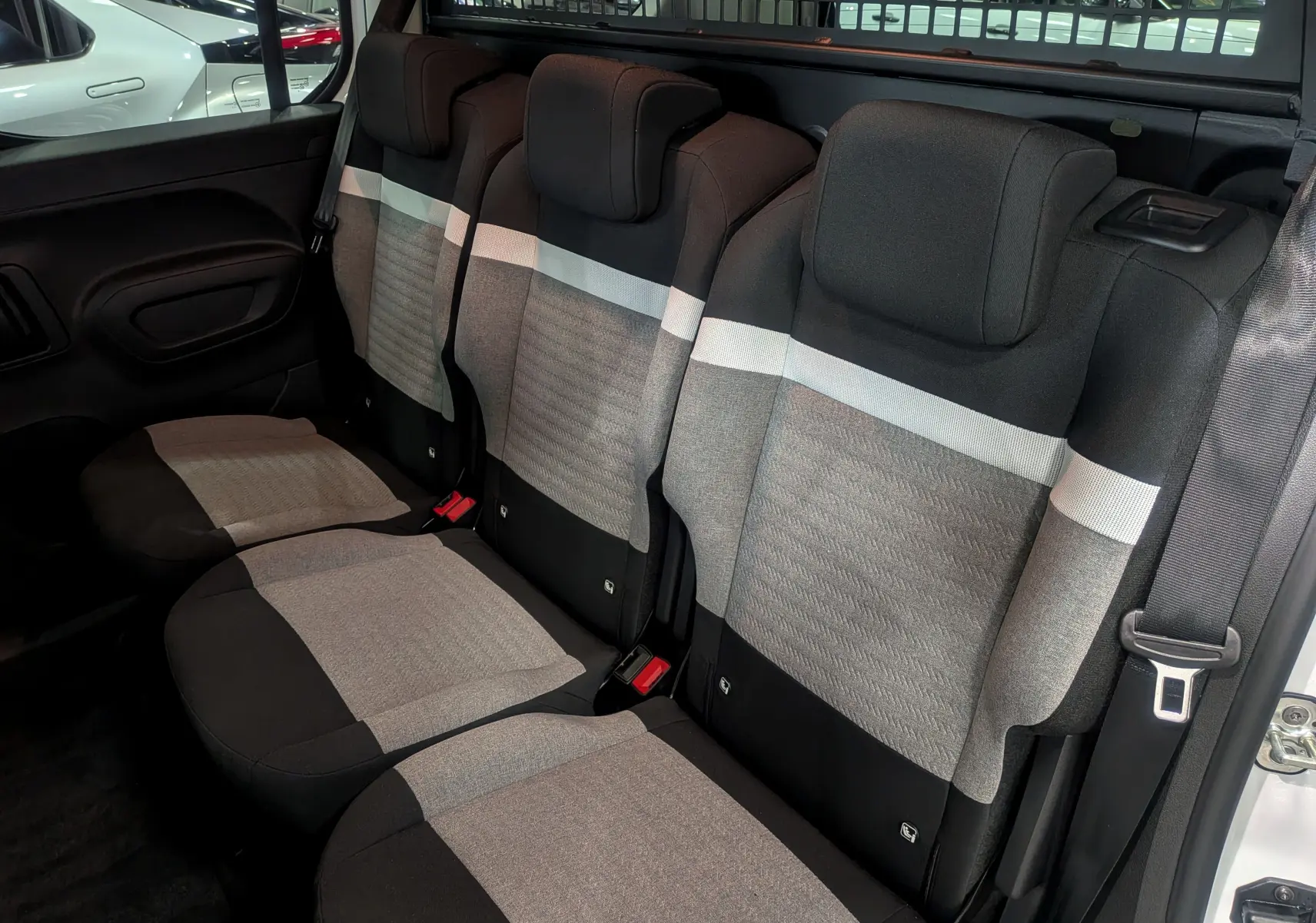 Vue intérieure des sièges arrière en tissu gris et noir du Citroën Berlingo Blanc Glacier 2025, version BlueHDi 130 CH EAT8 PLUS N1.