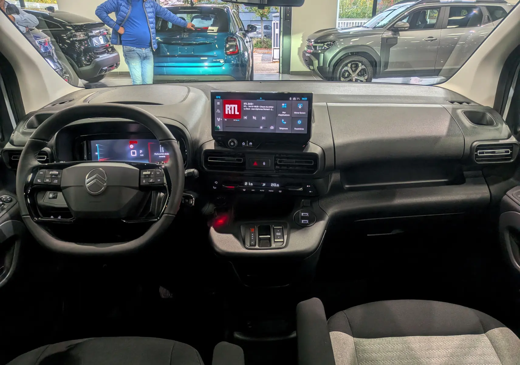 Vue intérieure frontale du tableau de bord du Citroën Berlingo 2025, avec écran tactile et volant multifonction noir.