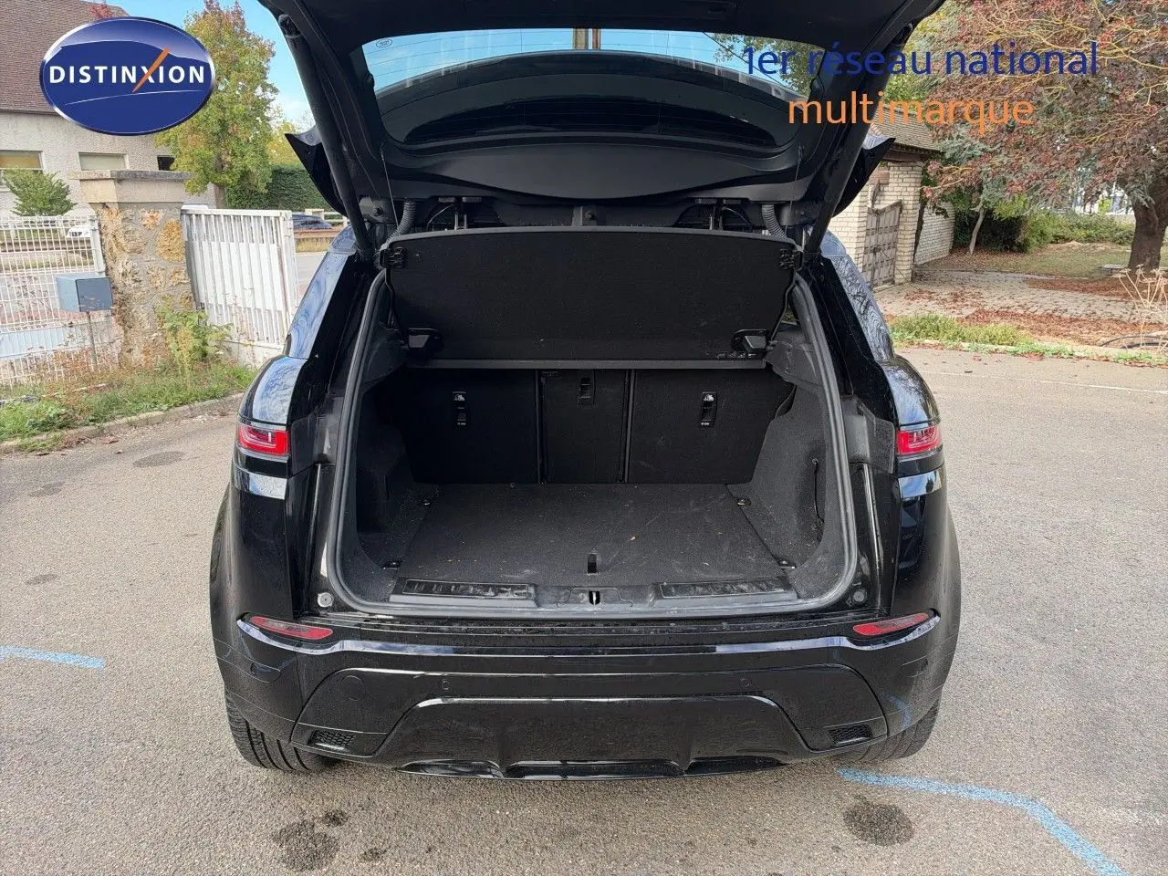 Vue arrière d'un Range Rover Evoque Santorini Black 2023 avec coffre ouvert, montrant l'espace de chargement vide.