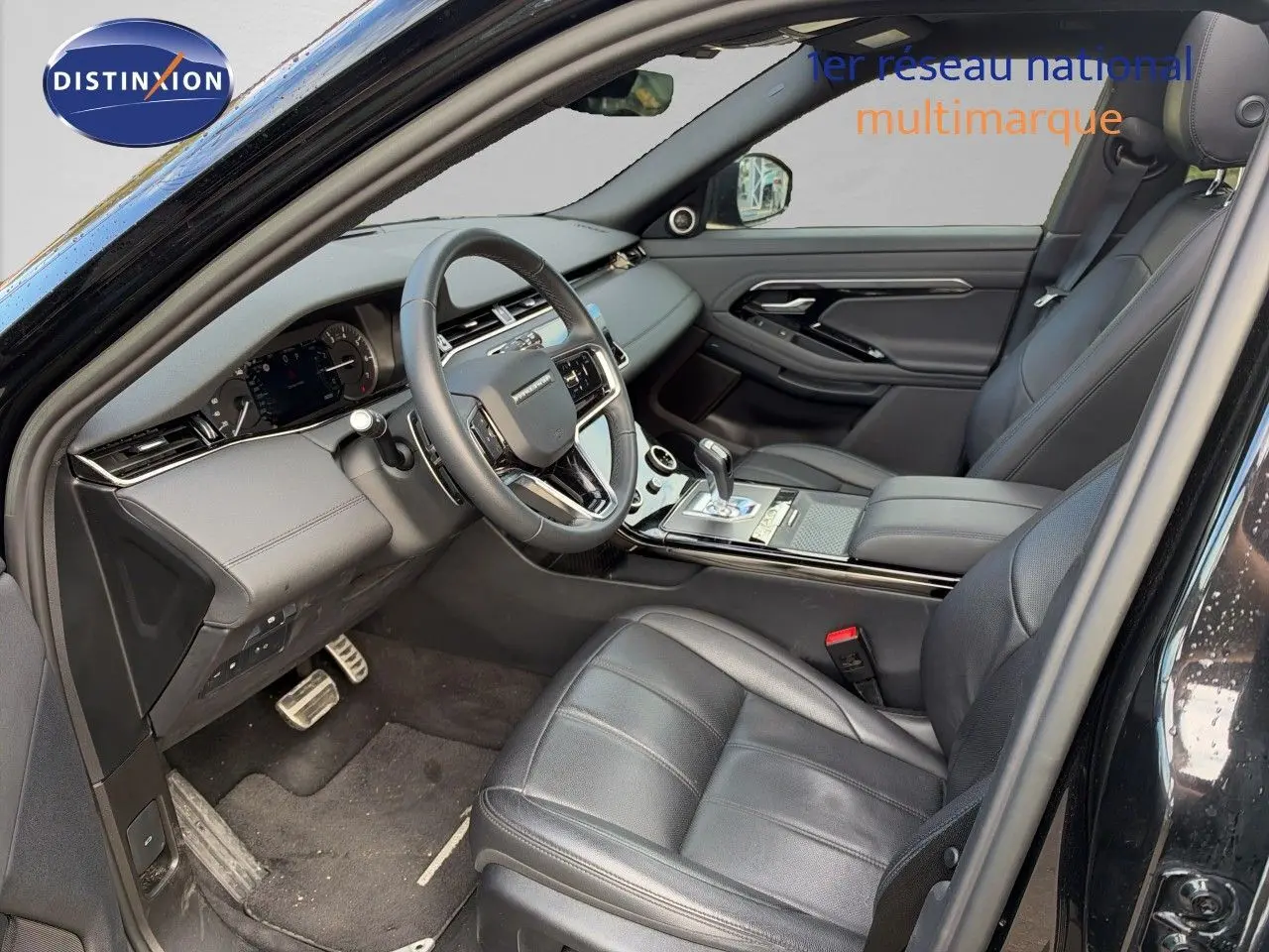 Intérieur du Range Rover Evoque 2023 en Santorini Black, vue côté conducteur montrant sièges cuir et tableau de bord moderne.