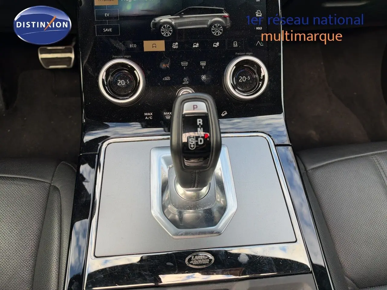 Gros plan sur la console centrale du Range Rover Evoque 2023 Santorini Black, avec levier de vitesse automatique et commandes tactiles.