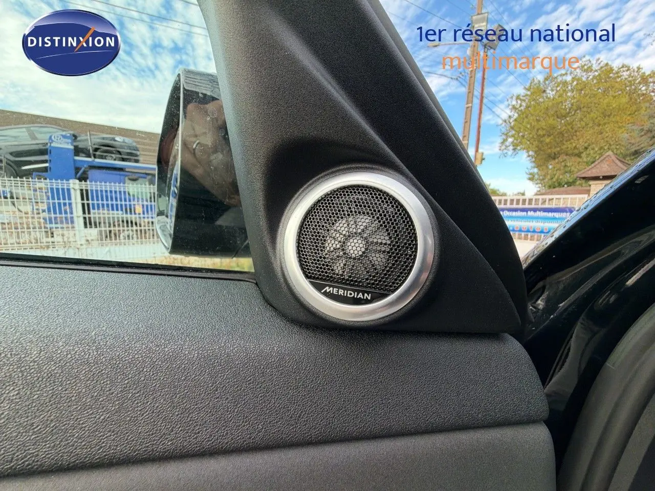 Gros plan sur l'enceinte Meridian intégrée à la porte côté gauche d'un Range Rover Evoque Santorini Black 2023.
