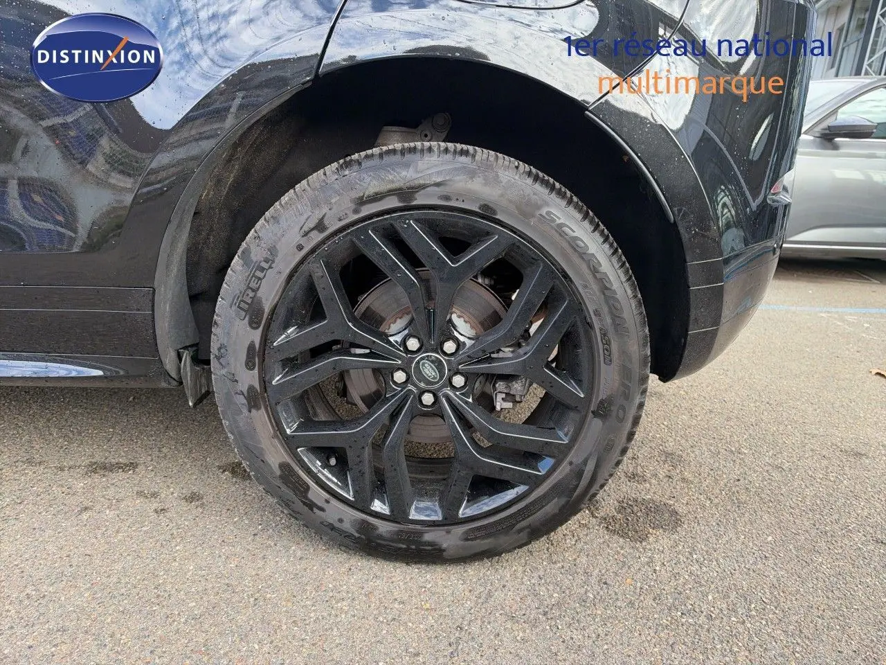 Gros plan sur la roue arrière gauche noire brillante d’un Range Rover Evoque Santorini Black avec jante alliage noire.