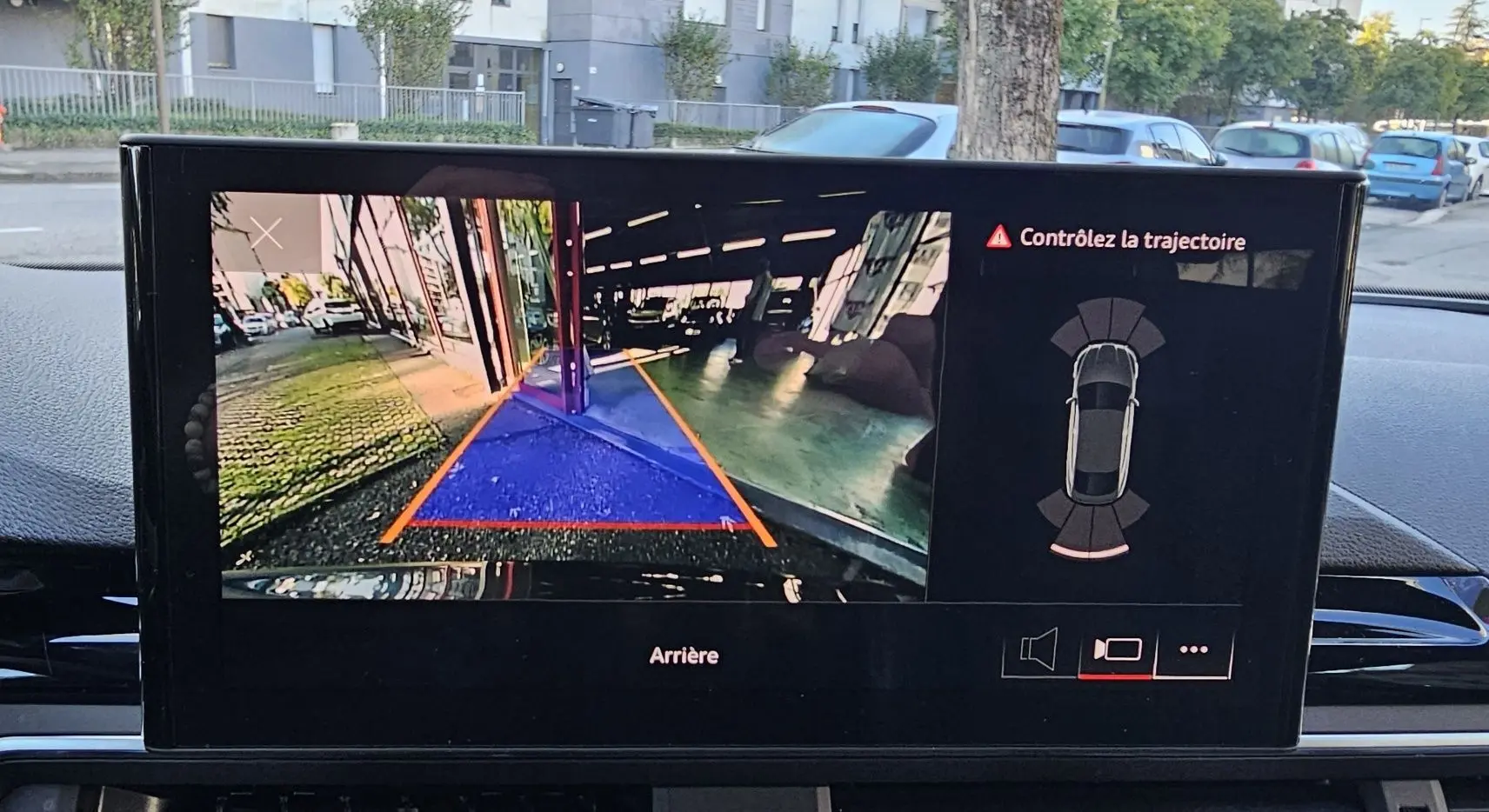 Vue de l'écran intérieur affichant la caméra de recul avec trajectoire assistée sur Audi A5 Sportback gris Daytona.