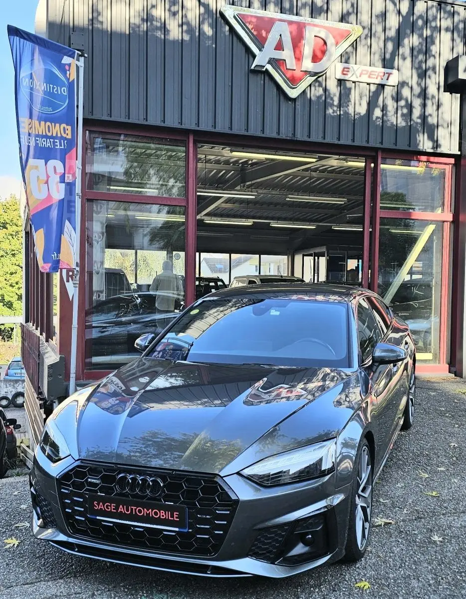 Audi A5 Sportback gris Daytona vue de face en léger 3/4 avant, avec calandre noire hexagonale et jantes sport.