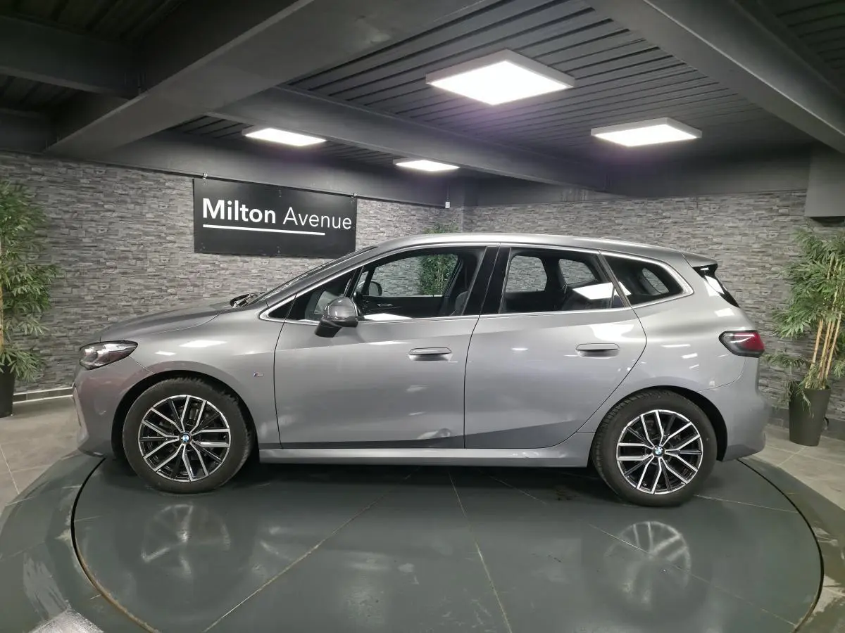 BMW Série 2 Active Tourer gris métallisé vue de profil côté gauche avec jantes alliage et poignées affleurantes.