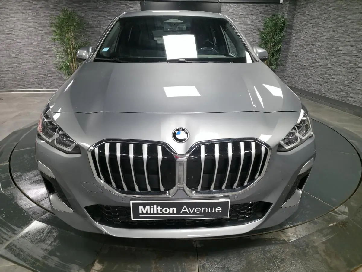 Vue frontale d'une BMW Série 2 218i Active Tourer gris métallisé avec calandre M Sport et phares LED intégrés.