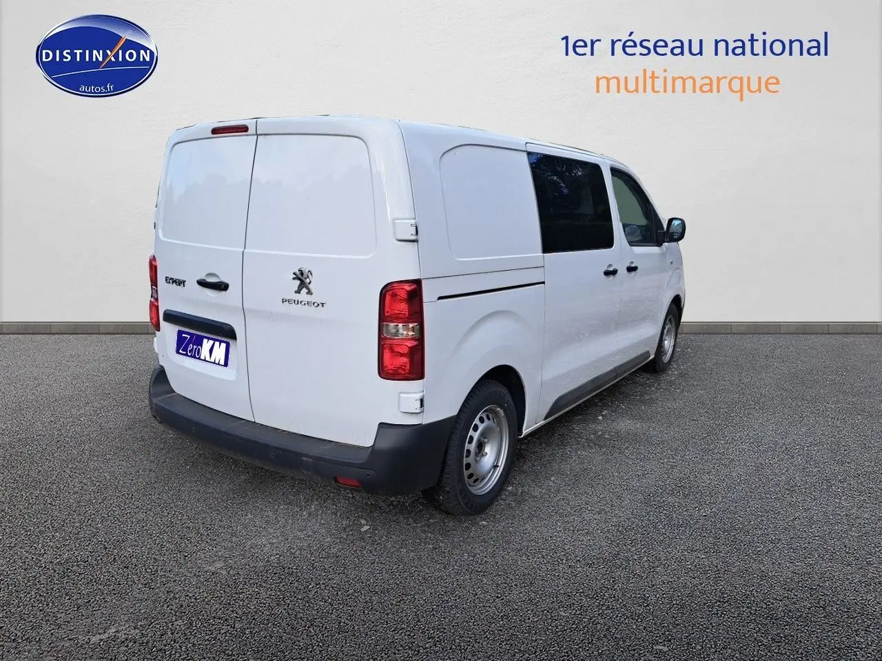 Vue 3/4 arrière droite d’un Peugeot Expert blanc Kaolin, fourgon utilitaire avec vitres teintées sur les portes avant.